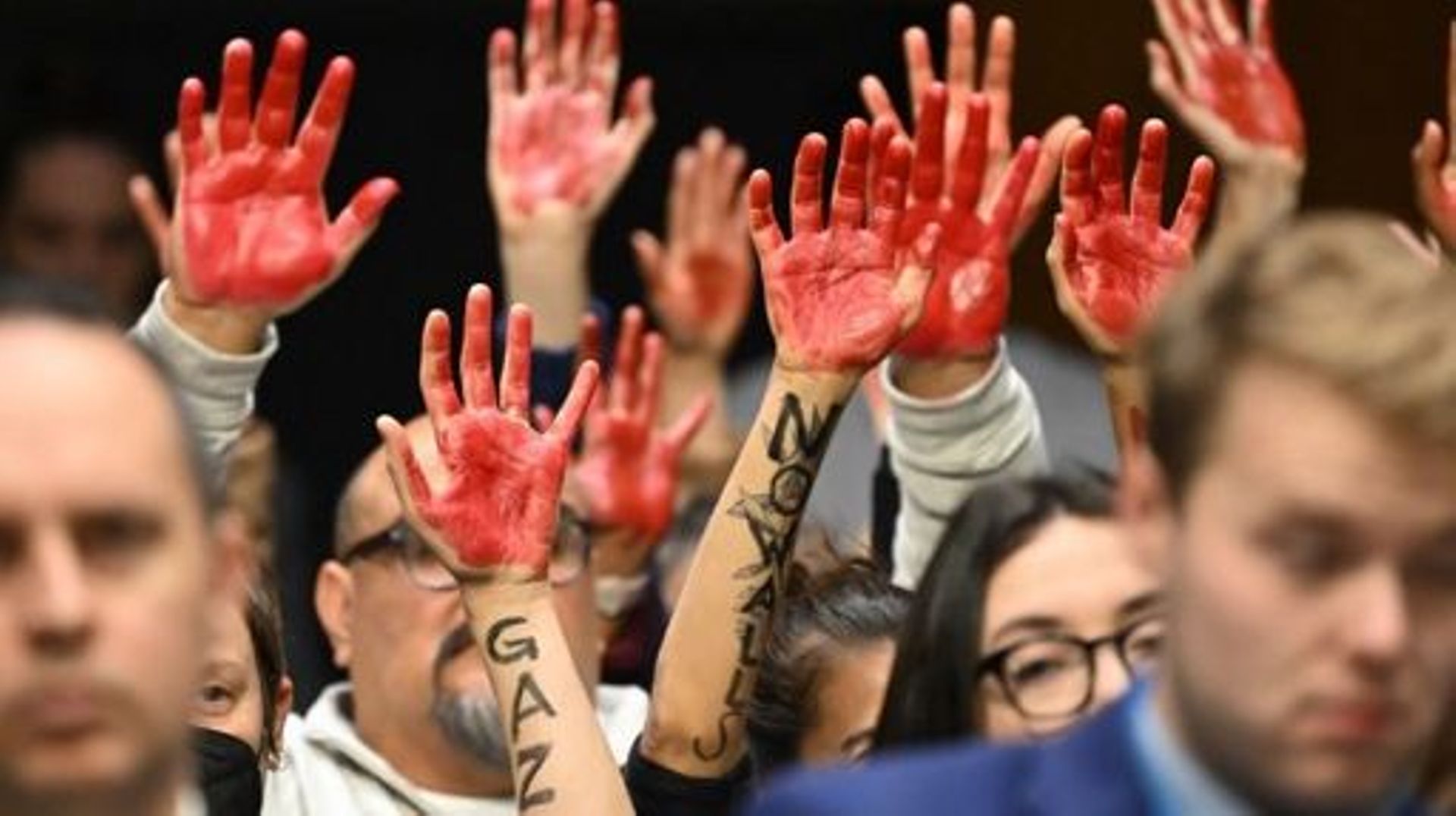 Des manifestants aux mains peinturlurées pour symboliser le sang des populations bombardées de Gaza.